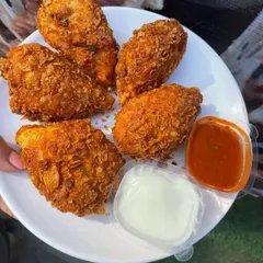 For a modern twist, I make these Kurkure Momos. Steamed dumplings are coated in a crunchy batter and deep-fried until golden. They offer a unique texture and are served with mayonnaise and a spicy momo chutney.
