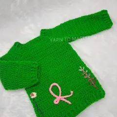 This vibrant green sweater is made with soft yarn and features delicate, hand-embroidered floral details and a simple ribbon, offering a touch of nature-inspired charm.