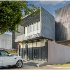 This perspective showcases the material contrast on our DLF Alameda project. The dark zinc shingles on the upper volume create a powerful visual anchor, while the vertical fins on the adjacent section add a layer of texture and privacy screening.