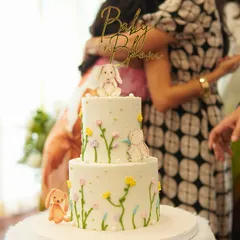 An adorable 'Baby in Bloom' cake, featuring delicate, hand-piped flowers and cute bunny figures. A beautiful and delicious centerpiece for a sweet baby shower celebration.