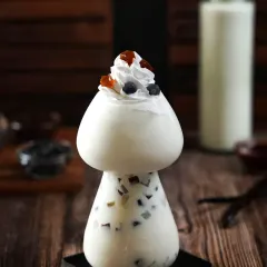 We love playing with unique glassware to tell a story. This mushroom-shaped glass adds a whimsical touch to this boba drink, while the dark, woody background and focused lighting highlight its creamy texture and toppings.