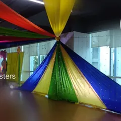 For this Dandiya night, we created a spectacular canopy using long, colorful fabric drapes radiating from a central point. This ceiling treatment completely transformed the indoor space, adding energy and a festive atmosphere.