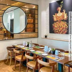 A detail shot from the Citrus Cafe in Bengaluru. We used a large circular mirror and bold, colorful artwork to create focal points and add personality to this dining corner.
