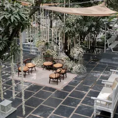 An ethereal all-white wedding ceremony setup. We used streams of delicate white flowers and baby's breath to create a dreamy, floating effect, transforming the venue into a serene and magical space for the couple to exchange vows.