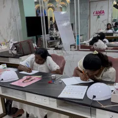 Students focused on their workbooks during the theory part of our Nail Technician course.