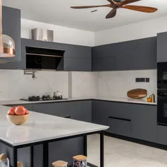 This modern U-shaped kitchen is designed for ultimate functionality. We used a combination of matte grey cabinets and a marble-patterned backsplash for a sleek, contemporary look. The space includes a small island for extra prep area and is equipped with a built-in oven and chimney hood.