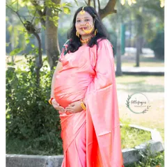 A stunning portrait of a mom-to-be in a pink Gadwal silk saree. The traditional jewelry and radiant smile make this a truly special and culturally rich maternity photo.