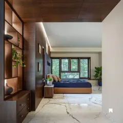 A bedroom in Kanasu designed as a tranquil retreat, with large windows framing the lush greenery outside and warm wood tones creating a cozy atmosphere.