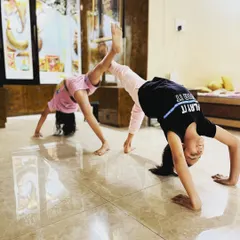 My students work together to create partner poses like this supported backbend. These exercises build trust, teamwork, and balance in our kids' yoga and flexibility classes.