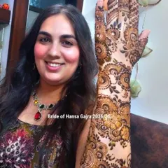 A portrait of a bride with her intricate floral mehendi. Her joyful expression and the detailed art on her arm create a stunning and memorable image.