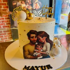 A lovely family portrait cake, featuring an edible image of a couple with their baby, decorated with elegant gold and white spheres.