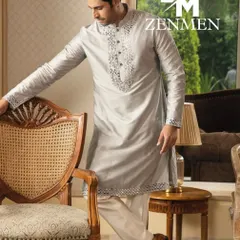 A model wearing a lustrous grey silk kurta with intricate mirror work along the placket and hem. A perfect blend of shimmer and sophistication.