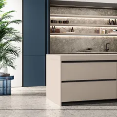 This image highlights our handleless drawer system on a kitchen island, creating a seamless and modern look. In the background, a recessed pantry with integrated shelf lighting provides both storage and a beautiful display area.
