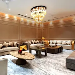 This expansive living room showcases our commitment to opulence and scale. We used Italian marble flooring to create a reflective, bright surface, while the grand chandelier and layered wall paneling add warmth and sophistication.