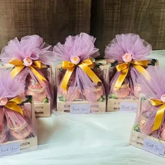 A bulk order of corporate gift hampers, beautifully wrapped in lavender net with gold ribbons. This presentation is perfect for large-scale corporate events or holiday gifting.