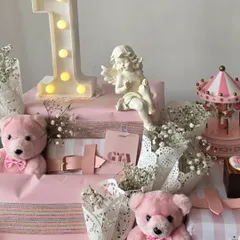 Celebrating a first birthday with this angelic pink hamper, featuring a light-up number '1', a miniature carousel, and sweet pink teddy bears.