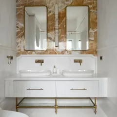 We transform bathrooms into personal spas. This award-winning master en-suite features a dramatic dialogue between Mango Onyx and White Balmain Marble, with custom fluted vanities and checkerboard flooring to create a space that is meant to be felt, not just seen.