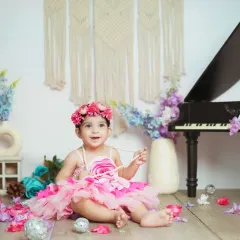 This little girl is dressed up for her milestone session, complete with a miniature piano and flowers. I have a wide range of props to make your baby's session unique.