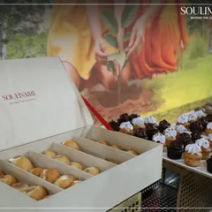 Our catering services extend to providing elegant pastries for corporate events. Here, a Soulinaire box is filled with freshly baked doughnuts, accompanied by a display of miniature chocolate cupcakes for a sustainable celebration.