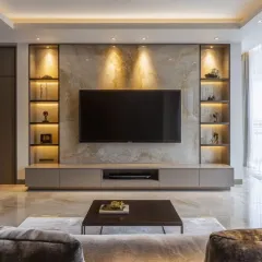 This television unit is designed as a sophisticated focal point, featuring a stunning marble accent wall flanked by custom, back-lit display shelves. The floating console provides sleek, minimalist storage, creating a look that is both functional and exceptionally stylish for a modern living room.