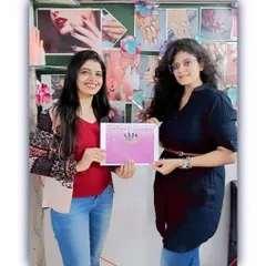 Celebrating another student's achievement. She is holding her certificate after successfully completing her training, ready to take on clients.