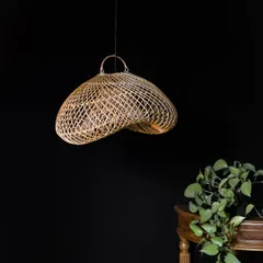 Unlit, the artistic form of this free-flowing rattan pendant is on full display. It resembles a natural form, like a sea creature or a delicate fungus, making it a unique piece of hanging art.
