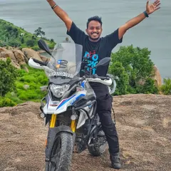 A rider and his BMW G310GS adventure bike posing against the backdrop of a beautiful lake. We welcome riders of all types of motorcycles, from adventure tourers to sportbikes.