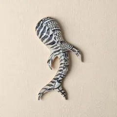 A fish sculpture with intricate black and white patterns. Fish embody an endless, flowing cycle of nourishment and fortune, making them timeless symbols of abundance for your home.