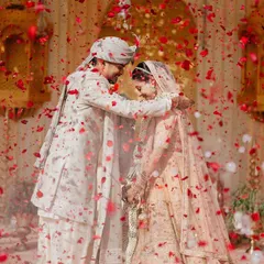 A magical moment during the varmala, with the couple showered in red rose petals. It's a picture of pure love and celebration.