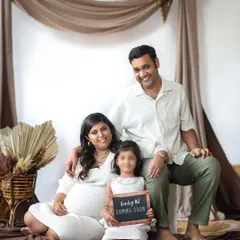 A lovely family maternity session announcing baby number two. The older sister-to-be holds a sign, making this a sweet and inclusive way to celebrate the growing family.