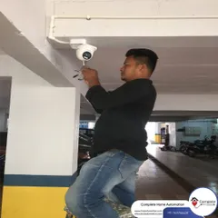 A technician mounts a dome camera in a parking garage. We take great care in selecting the right camera position to maximize the field of view and cover critical areas.