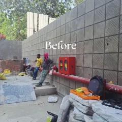 Another 'Before' shot showing the empty wall and the ground being prepared for the installation. Our work involves transforming these underutilized spaces completely.