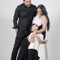 A classic family portrait in coordinating black outfits. Our Veneccia gown is a sophisticated choice for a timeless family photo.