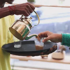 Nothing beats the comfort of a perfectly brewed cup of chai. Here you can see us pouring our special Kolkata-style tea from a traditional brass kettle. We serve it hot and fresh, making it a highlight for any get-together or party.