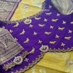 A close-up of our signature jewellery-concept blouse. This royal purple silk blouse is adorned with hand-embroidered mango motifs and kemp stone pendants, creating a look that is both traditional and opulent.