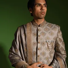 This angle highlights the structure and fit of the steel grey sherwani. Notice the hand embroidered zardozi buttons and the subtle chain brooch, which are signature details I add to elevate the garment.