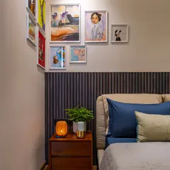 We believe in creating spaces for personal expression, like this art nook above the bed's headboard. The gallery wall allows the homeowner to display personal paintings, making the space uniquely their own.