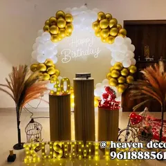 An elegant 40th birthday celebration with a circular balloon arch in chrome gold and white. The setup includes a neon "Happy Birthday" sign, pampas grass arrangements, and light-up marquee letters.