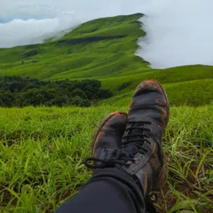 Kicking back and relaxing with muddy boots after a rewarding trek to Netravathi peak. The view of the cloud-kissed green hills is the perfect reward.