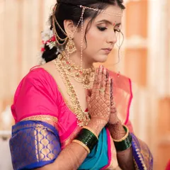 A moment of quiet reflection before the ceremony. We focused on elegant details like the intricate matha patti and soft makeup to complement her traditional South Indian bridal attire.