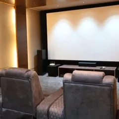 This is the end result we aim for: a clean, professional home theater where the technology is perfectly integrated. The focus is on the experience, with comfortable seating, a large screen, and immersive sound, all controlled effortlessly.