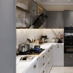 A closer view of the cooking area, showing the fluted glass upper cabinets with internal lighting. This detail adds a touch of elegance and allows for the display of fine crockery.