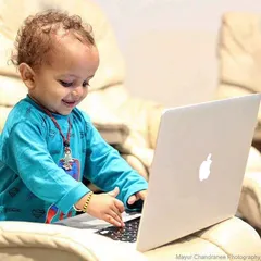 In today's world, even the youngest children have a special connection with technology. This candid shot captures a moment of curious exploration with a laptop.
