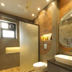 The shower area features a frosted glass partition for privacy, and the vanity unit continues the semi-circle motif for a cohesive design.