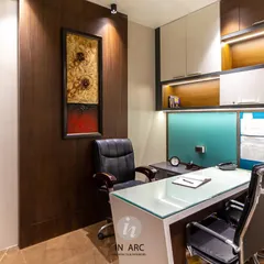 This is a director's cabin we designed for an educational institute in Nandigram. The space combines warm wood veneers with cool tones and strategic accent lighting to create an environment that is professional, focused, and sophisticated. Every element, from the glass-top desk to the built-in shelving, is chosen for function and style.