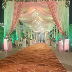 This grand entrance walkway is designed for a truly royal feel. Draped in soft peach and cream fabrics and illuminated by elegant chandeliers, it creates a warm and inviting passage for guests.