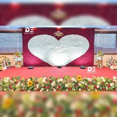 A wide view of the magnificent red and white rose wall, designed as a reception stage backdrop. The sheer scale of the floral installation creates an unforgettable visual impact.