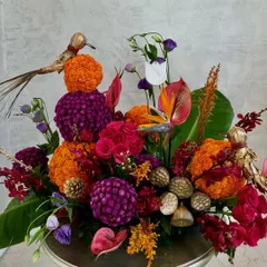 A festive arrangement perfect for Diwali. I combined traditional marigolds with exotic anthuriums, roses, and decorative birds to create a piece that is both celebratory and artistically unique.