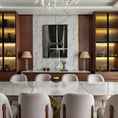 A head-on view of the dining set, showcasing the ten-seater table with its sculpted brass base. The surrounding display cabinets with internal lighting were also crafted by us to complete the room.