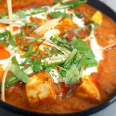 Our Paneer Butter Masala is a crowd favourite. We use soft paneer cubes in a rich, creamy tomato gravy, garnished with fresh coriander and ginger for that perfect finish.